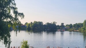 A lakeside scene with people swimming and relaxing by the shore. - Cozy vacation apartment for 1 to 4 people. Perfect for a little time out  (Frielendorf)
