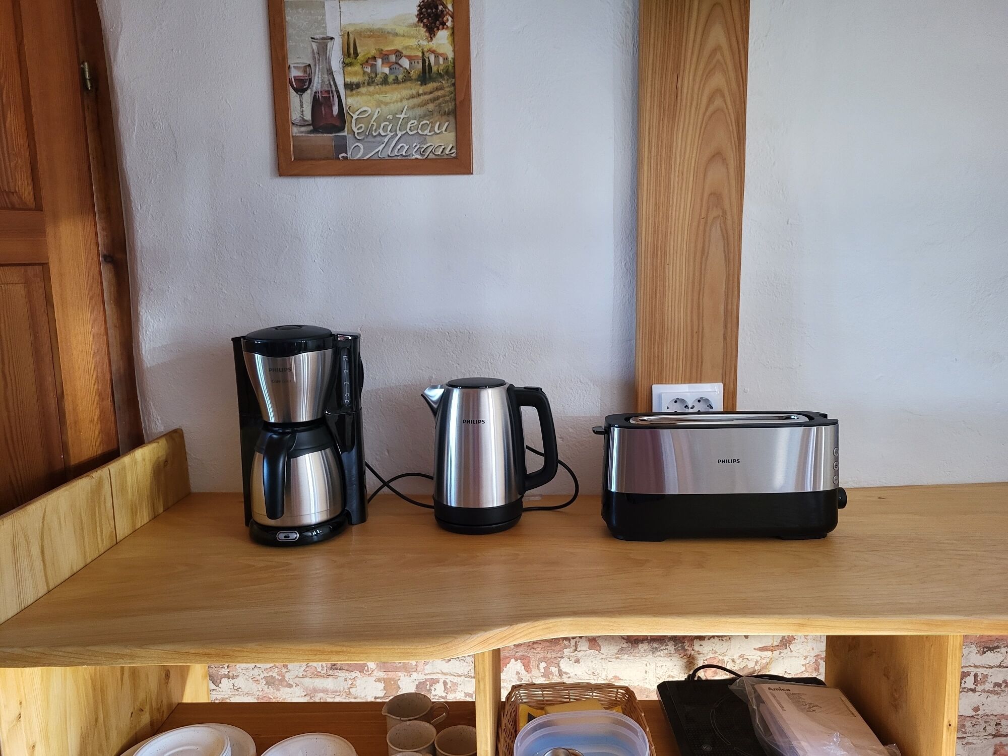 A kitchen counter with a coffee maker, a kettle, and a toaster.