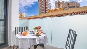 A balcony with a table set for breakfast, including croissants, fruit, and orange juice. - SUITE MARINA BEACH COSTA DEL SOL (Fuengirola)