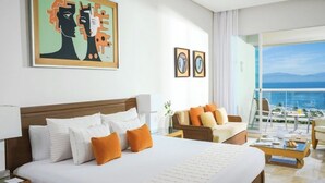 Ett hotellrum med en stor säng, en soffa, ett soffbord och en balkong med utsikt.