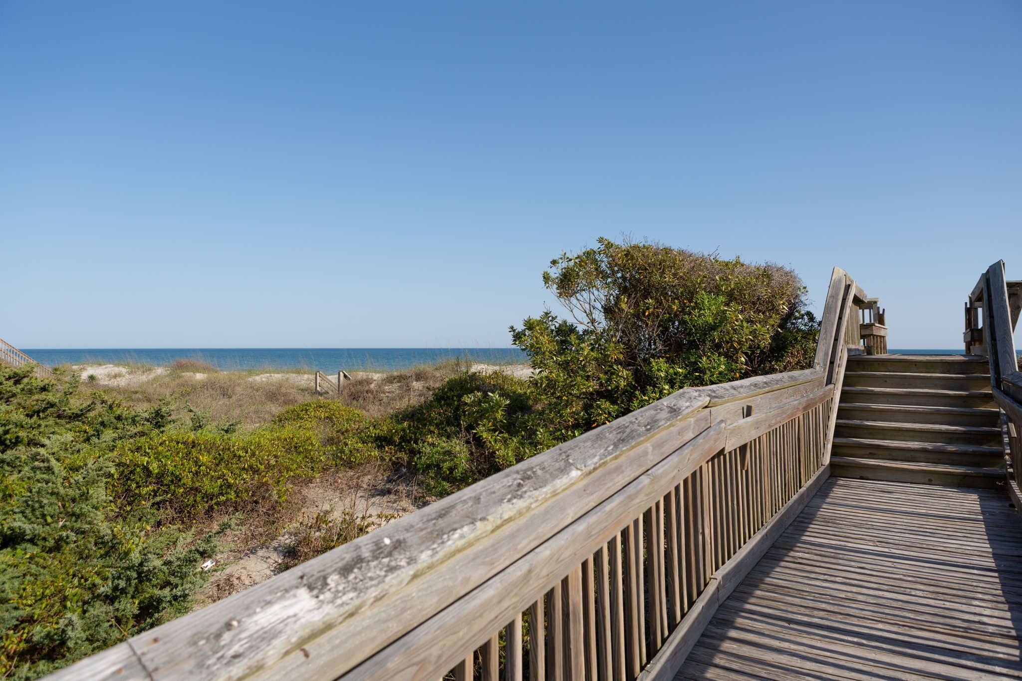 Una pasarela de madera que conduce a una playa con una vista despejada del océano.