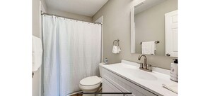 Een bad/douchecombinatie, een haardroger, handdoeken, zeep