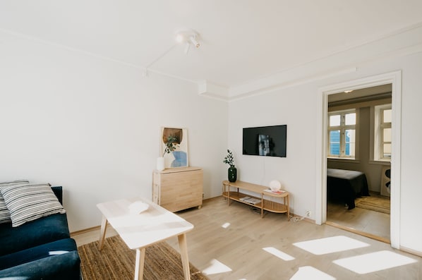 A modern living room with a sofa, a coffee table, a TV, and a wooden cabinet.