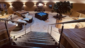 A modern interior with a hot tub, seating area, and a staircase. - Wellness-Speicher vacation apartment with sauna, whirlpool, breakfast and more (Freital)