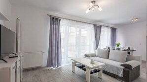 A modern living room with a sofa, coffee table, and a TV on a stand. - Vacation apartment by the sea, vacation on the island of Usedom, Apartment FLOTYLLA 13 (Swinoujscie)