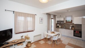 Une cuisine moderne avec des meubles blancs, un four à micro-ondes, un grille-pain et une cuisinière.