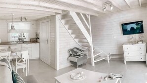 Un intérieur moderne avec un escalier, des meubles blancs et un téléviseur à écran plat.