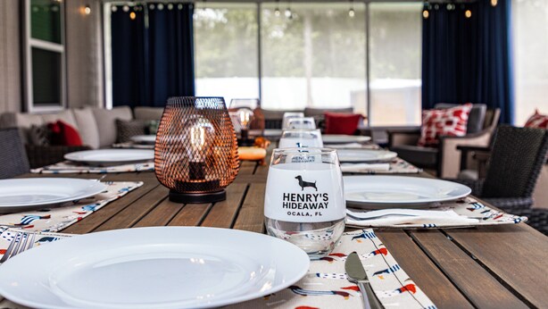 A dining table set with plates, a wine glass, and a candle.