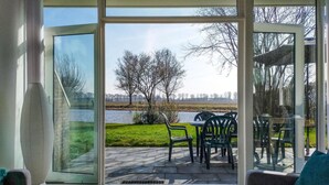 Una habitación moderna con un amplio ventanal corredero que da a un patio exterior con una mesa y sillas.