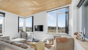 A modern living room with large windows, a flat-screen TV, and a cozy seating area. - 3 bedroom lovely home in Fjerritslev (Fjerritslev)