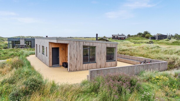 A modern, single-story house with a wooden exterior, large windows, and a sandy courtyard. - 3 bedroom lovely home in Fjerritslev (Fjerritslev)