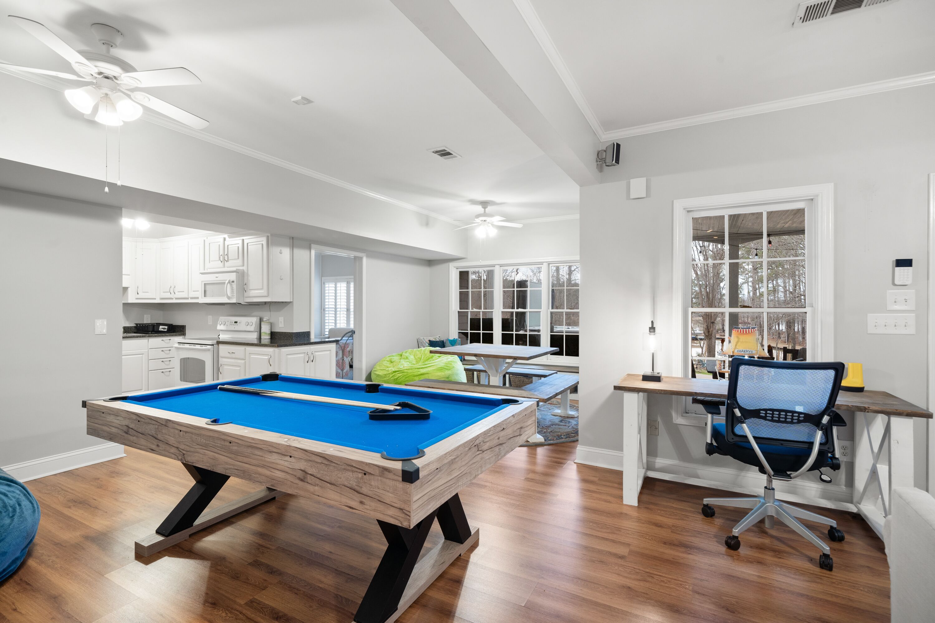 Una habitación amplia con mesa de billar, comedor y cocina.