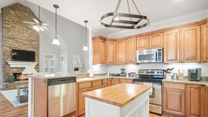 Una cocina moderna con armarios de madera, electrodomésticos de acero inoxidable y una isla central.