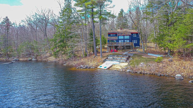 Eine Hütte am See mit einem Steg, der ins Wasser führt.