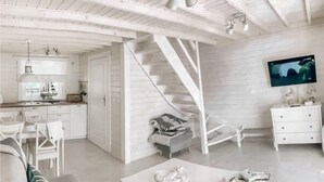 Un intérieur moderne avec un escalier, des meubles blancs et un téléviseur à écran plat.