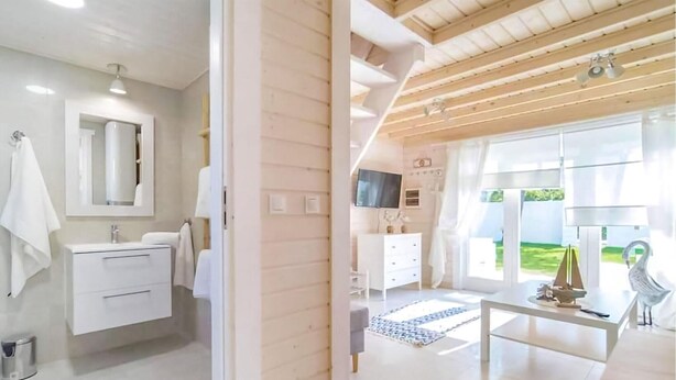 Une salle de bain moderne avec un grand miroir, des meubles blancs et un lavabo.