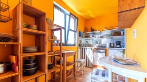 A compact kitchen with wooden shelves, a dining table, and a window providing natural light. - Beautiful home in Marusici (Omis) with WiFi (Marusici (Omis))