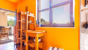 A kitchen with wooden shelves, a window, and a view of the outside. - Beautiful home in Marusici (Omis) with WiFi (Marusici (Omis))