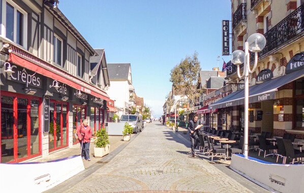 A cobblestone street lined with cafes and a hotel. - 2 bedroom nice home in Hermanville-sur-mer (Hermanville-sur-mer)