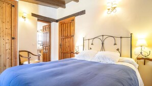 A bedroom with a large bed, wooden wardrobe, and two wall-mounted lamps. - 1 bedroom cozy apartment in Mondron (Mondron)