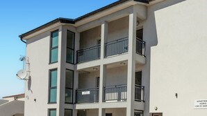 A multi-story apartment building with balconies and satellite dishes.