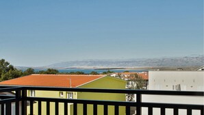 A balcony with a view of a mountain range and a body of water.