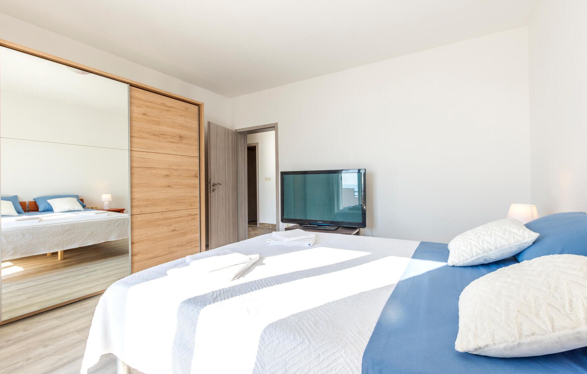 Une chambre d’hôtel avec un lit, une télévision et une armoire.