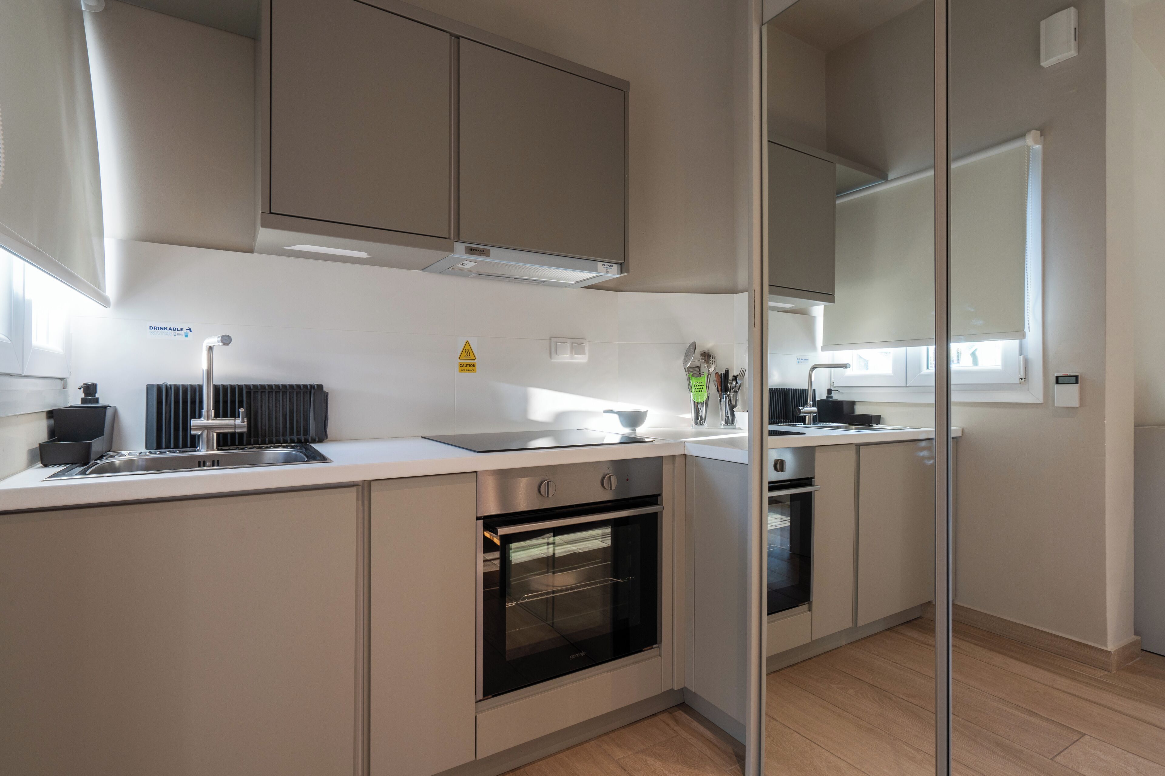 Una cocina moderna con electrodomésticos de acero inoxidable, horno empotrado y un amplio ventanal que proporciona luz natural.