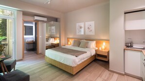 Een moderne slaapkamer met een groot bed, nachtkastjes, een inbouwkast en een kleine kitchenette.