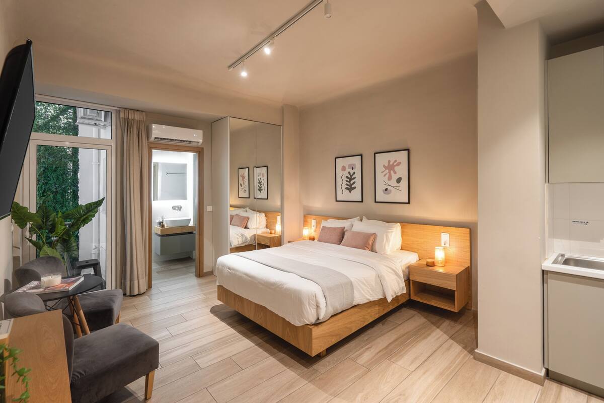 Ein modernes Schlafzimmer mit einem großen Bett, Nachttischen, einem Schreibtisch und einem Spiegel.