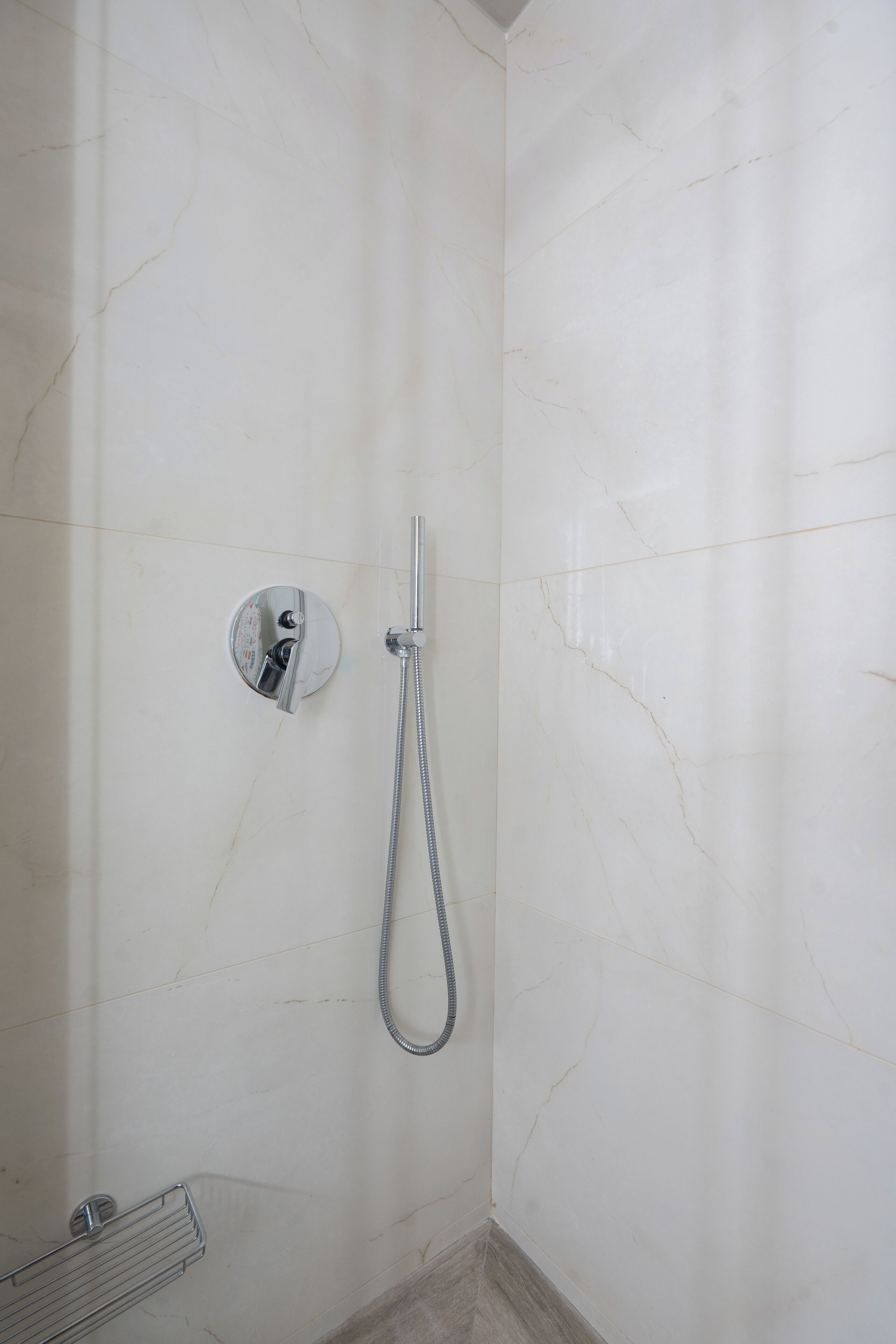 A bathroom with a shower, a towel rack, and a toilet.