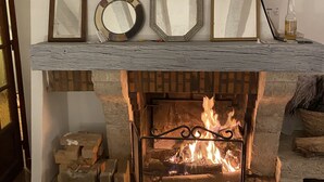 A fireplace with a mantel displaying three framed mirrors and a bottle. - Family home, its park and streams, on the route des Châteaux (Huisseau-sur-Mauves)