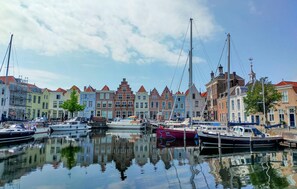Een jachthaven met afgemeerde boten, omringd door kleurrijke gebouwen met traditionele architectuur.