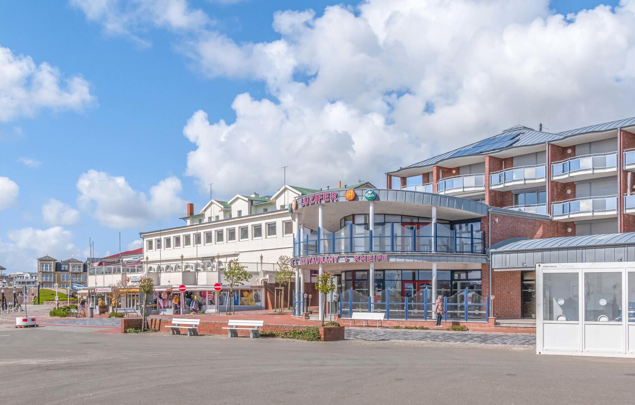 En modern byggnad med en restaurang som heter ”LUZIFER” och en bar som heter ”KNEIPE” på bottenvåningen.