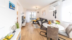 A modern apartment with a dining area, living room, and kitchen.