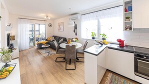 A modern kitchen with a dining area, featuring a round table, chairs, and a built-in oven.
