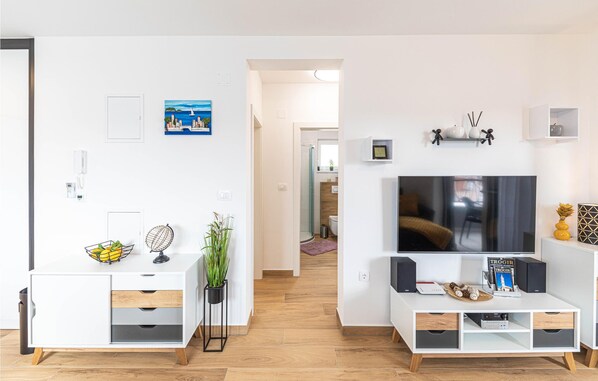 A modern living room with a white TV stand, a flat-screen TV, and a white cabinet with drawers. - 2 bedroom nice apartment in Trogir (Trogir)