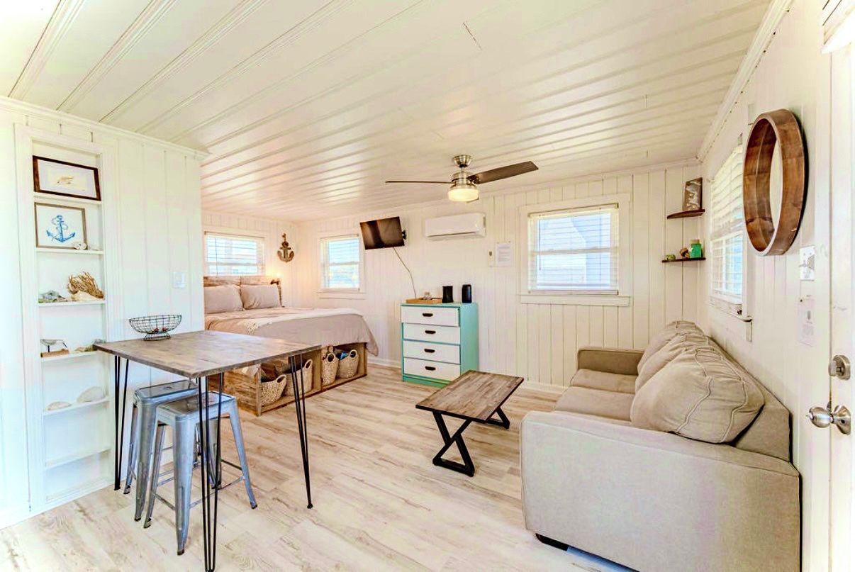 Un espacio habitable compacto con kitchenette, comedor y zona de estar.