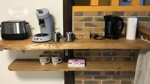 A kitchen counter with a coffee maker, a toaster, and a box of coffee pods.