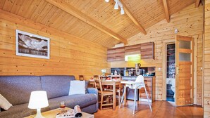 L'interno di una baita in legno con zona living, sala da pranzo e cucina.