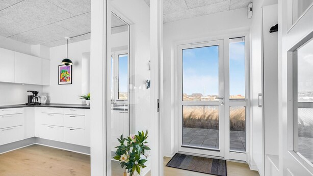 A modern kitchen with white cabinets, a coffee machine, and a potted plant. - Awesome apartment in Ringkøbing (Ringkøbing)