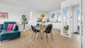 A modern apartment with a dining area, a living room with a sofa, and a kitchen. - Awesome apartment in Ringkøbing (Ringkøbing)