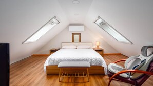 A bedroom with a sloped ceiling, skylights, a bed, a bedside table, a chair, and a lamp. - Nice apartment in Sinj with WiFi (Sinj)