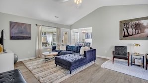 A spacious living room with a sectional sofa, a round coffee table, and a ceiling fan. - Pet Friendly Fenced Backyard Game Room Patio Firepit Trailer Motorcycle Parking (Myrtle Beach)