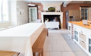 Enjoy meals together at the dining table for four, surrounded by a warm fireplace and modern kitchen amenities.