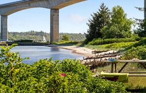 Une vue sur le fleuve, avec un pont, de la verdure et un quai pour bateaux.