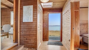 Ein Holzhütten-Interieur mit einer Karte an der Wand, einem Essbereich und Blick auf einen See.