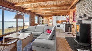 Ein gemütliches Blockhaus-Interieur mit Wohnbereich, Küche und Kamin.