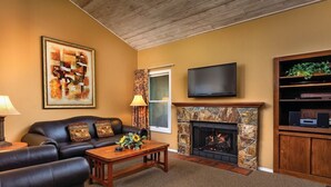 A living room with a fireplace, leather sofa, coffee table, and a flat-screen TV. - Price REDUCED  2Bed 2Bath, Full Kitchen & dining area, Washer/Dryer. Golf nearby (Flagstaff)