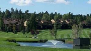 A golf course with a pond, a fountain, and a row of residential buildings in the background. - Price REDUCED  2Bed 2Bath, Full Kitchen & dining area, Washer/Dryer. Golf nearby (Flagstaff)
